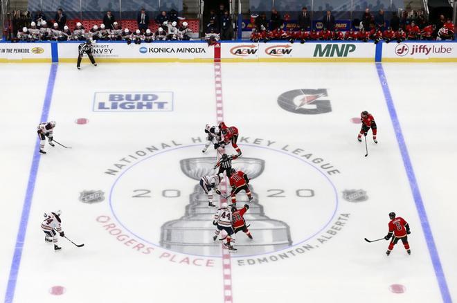 Connor McDavid # 97 de los Edmonton Oilers se enfrenta a Mikael Backlund # 11 de Calgary Flames para comenzar el primer período de un juego de exhibición antes de los playoffs de la NHL Stanley Cup 2020.