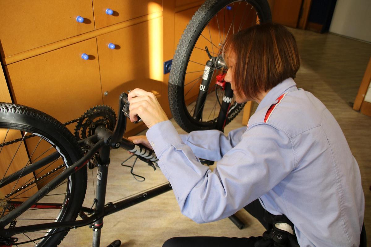 Una agent de Mossos revisant el número de bastidor d'una bicicleta recuperada.