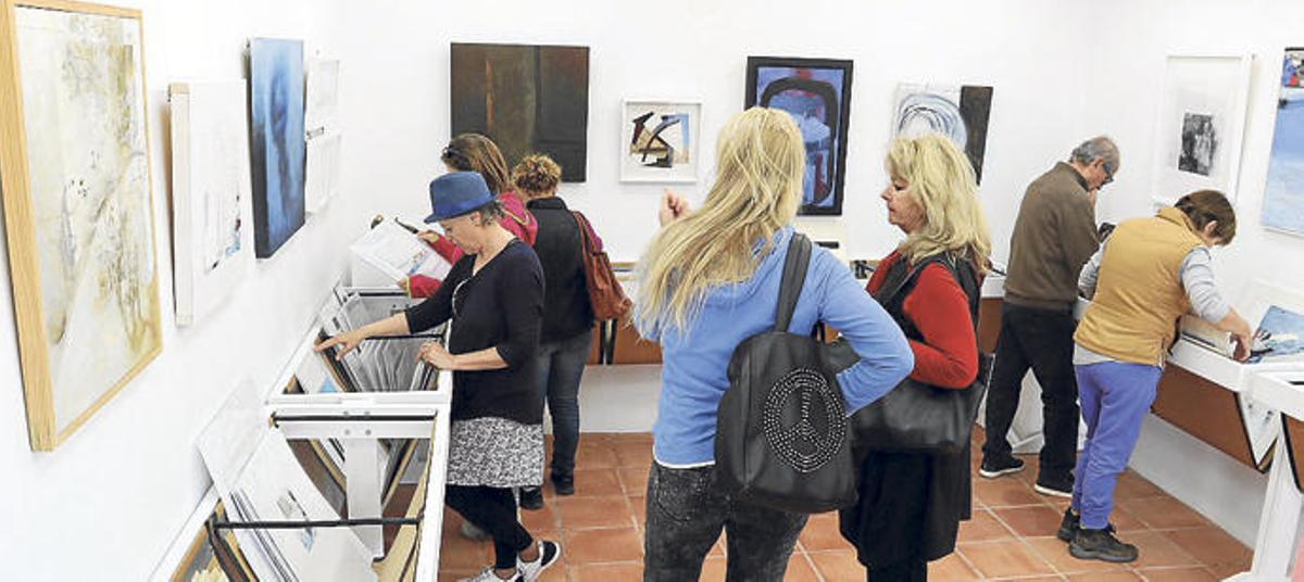 Varias personas miran las obras en el Supermercat de l´Art del año pasado.