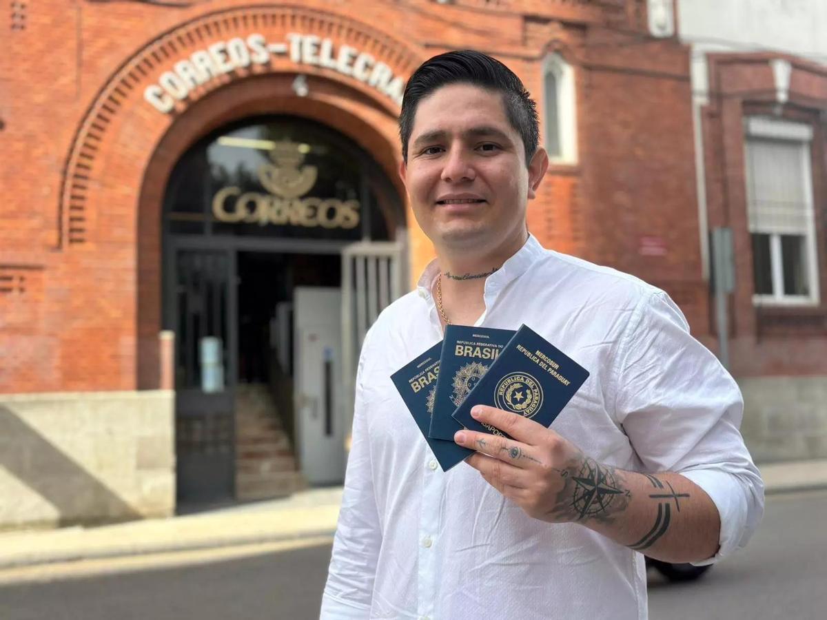 Carlos Caballero, brasileño de 30 años, con los pasaportes de su familia en la mano.