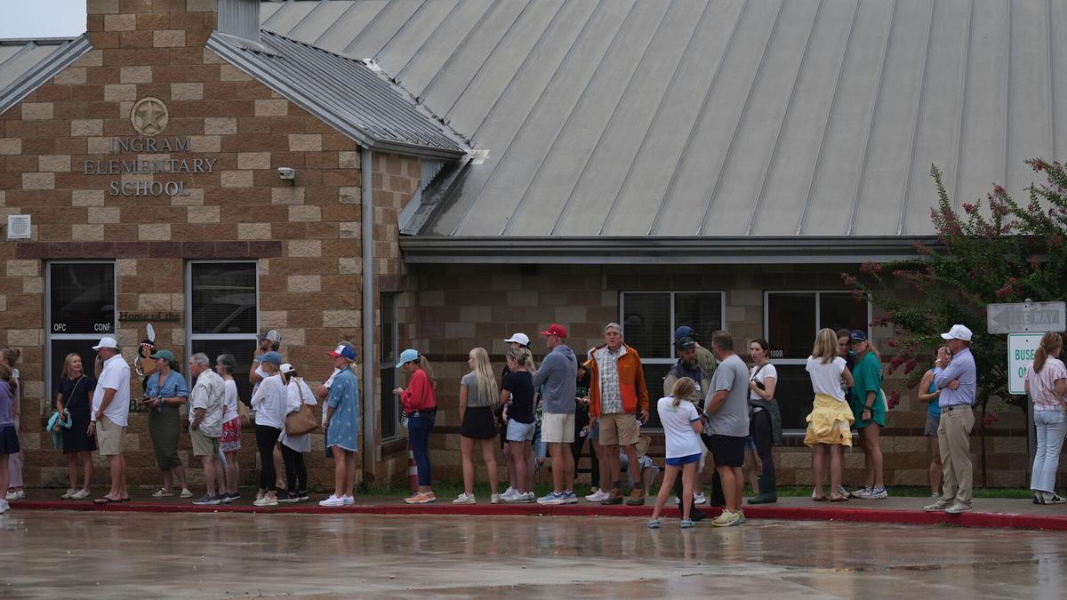 Families line up at a reunification center after flash flooding it the area, Friday, July 4, 2025, in Ingram, Texas. (AP Photo/Eric Gay)