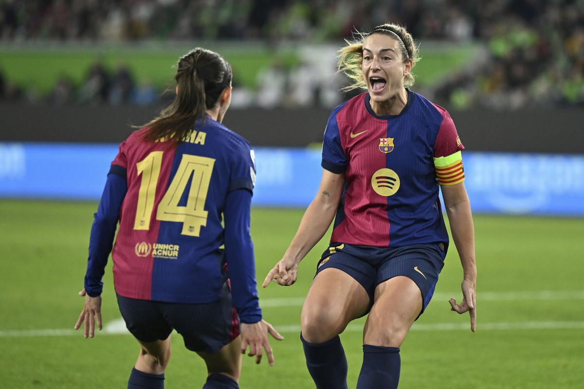 Barcelona's players Alexia Putellas, right, and Aitana Bonmati celebrate the opening goal during the Women's Champions League, quarter-final first leg, soccer match between VfL Wolfsburg and FC Barcelona in Wolfsburg, Germany, Wednesday, March 19, 2025. (Swen Pfoertner/dpa via AP). THE DEUTSCHE FUSSBALL LIGA DFL DOES NOT ALLOW ITS IMAGES TO BE USED AS SEQUENCES TO EMULATE VIDEO; GERMANY OUT; MANDATORY CREDIT