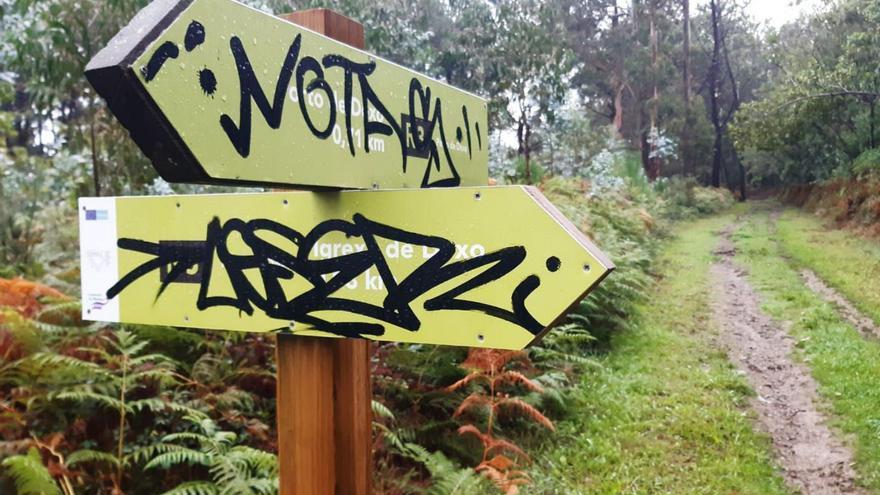 Pintadas en carteles de una ruta senderista a Dexo. |  // LA OPINIÓN