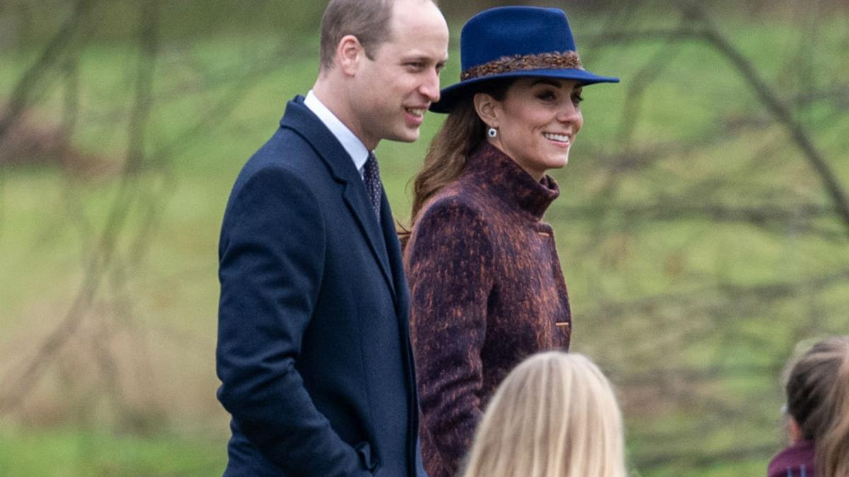 Kate Middleton con sombrero azul junto al Príncipe William