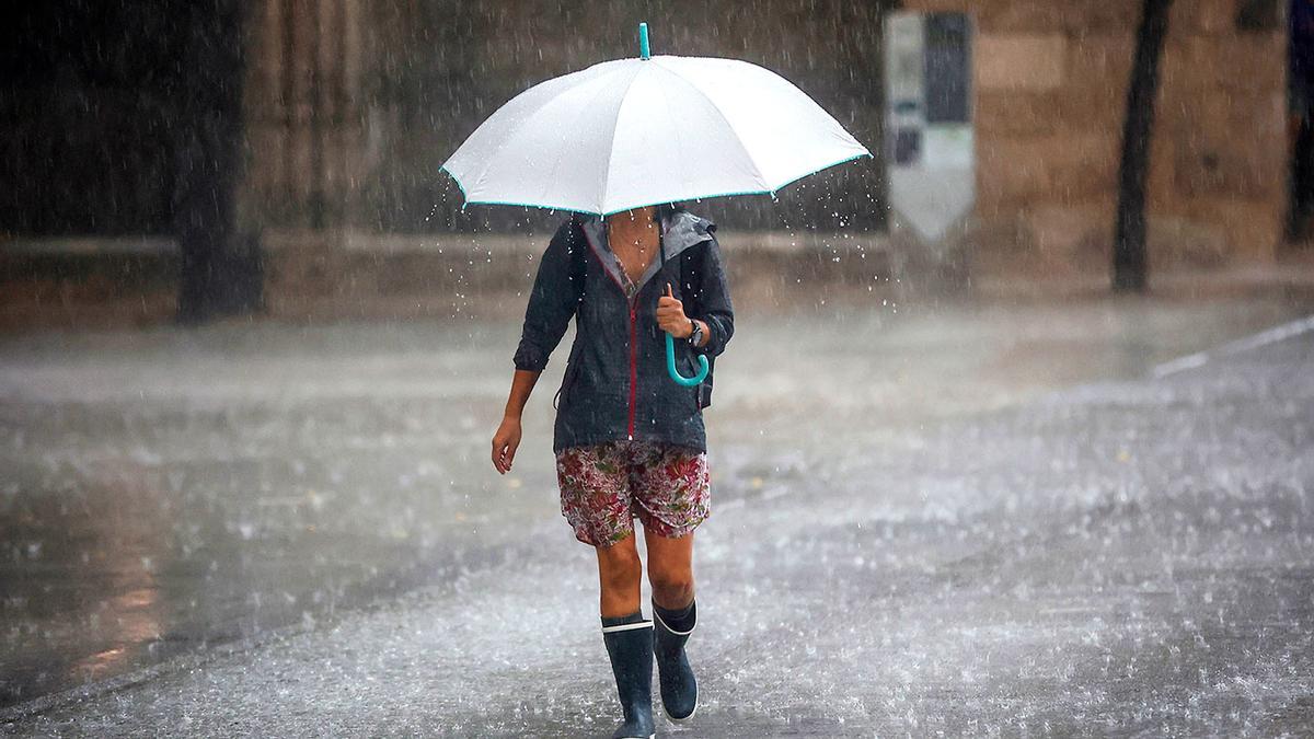 Una mujer se resguarda contra la lluvia.