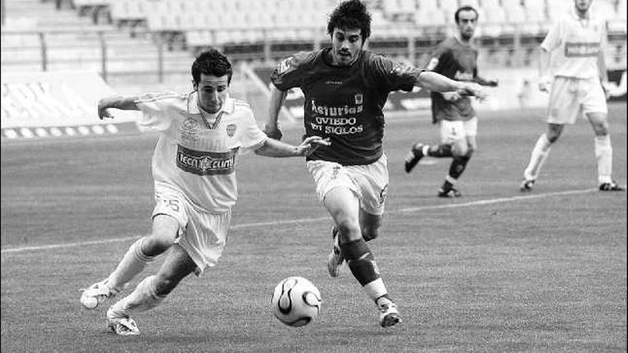 Santos y un jugador de la Juventud Asturiana pugnan por un balón.