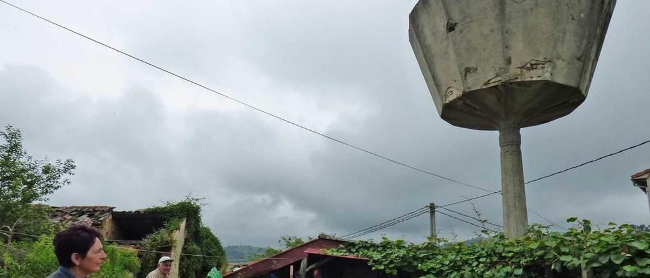 Pilar Regueiro y Pachu Menéndez, en su finca, contemplan el depósito de agua de Carbayín Alto.