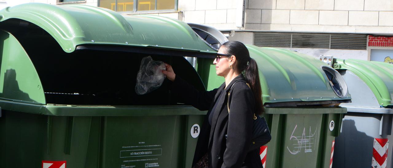 Una vecina deposita ayer una bolsa de residuos en un contenedor verde en el centro de Cangas.