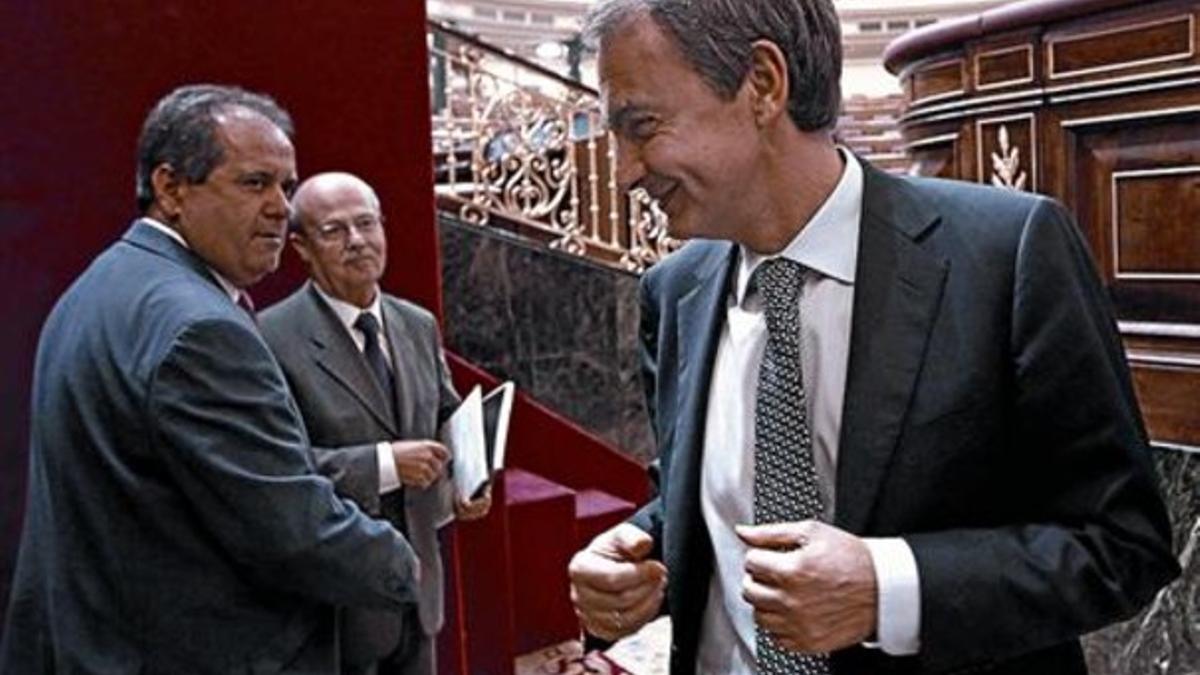 Zapatero habla con un diputado del PSOE por Canarias y otro de Coalición Canaria, ayer en el Congreso.