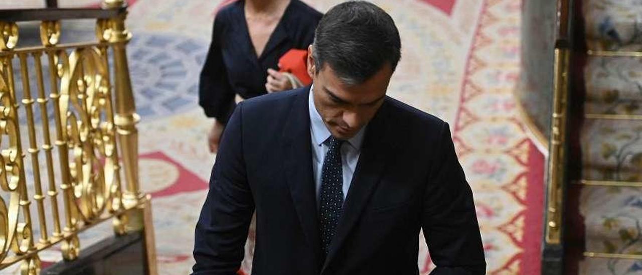 Pedro Sánchez abandona el hemiciclo del Congreso con gesto adusto tras la última sesión de control al Gobierno, el miércoles pasado, ante la mirada de la vicepresidenta, Carmen Calvo. // Efe