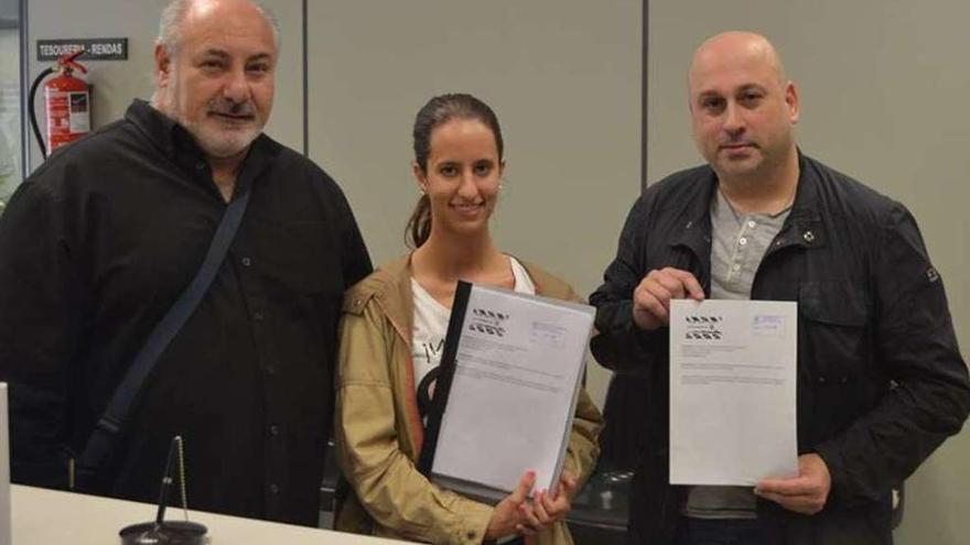 Tres integrantes del colectivo La Ciudad en B durante la entrega de firmas en el Concello de Betanzos.