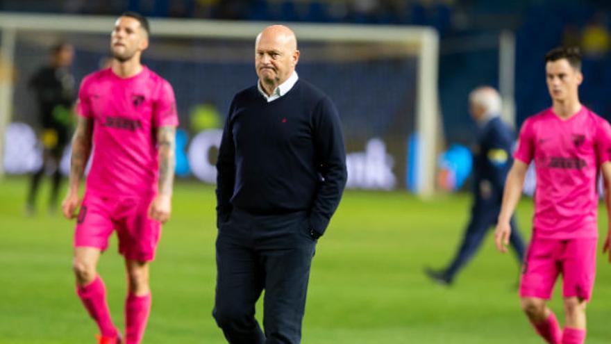 El técnico de la UD, José Mel Pérez, abandona resignado el terreno de juego. Detrás, el atacante del Málaga Tete.