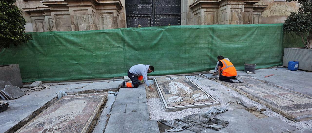 Operarios asentando ayer los tres mosaicos, obra de Sixto Marco sobre el drama asuncionista, a las puertas de Santa María.  | ANTONIO AMORÓS