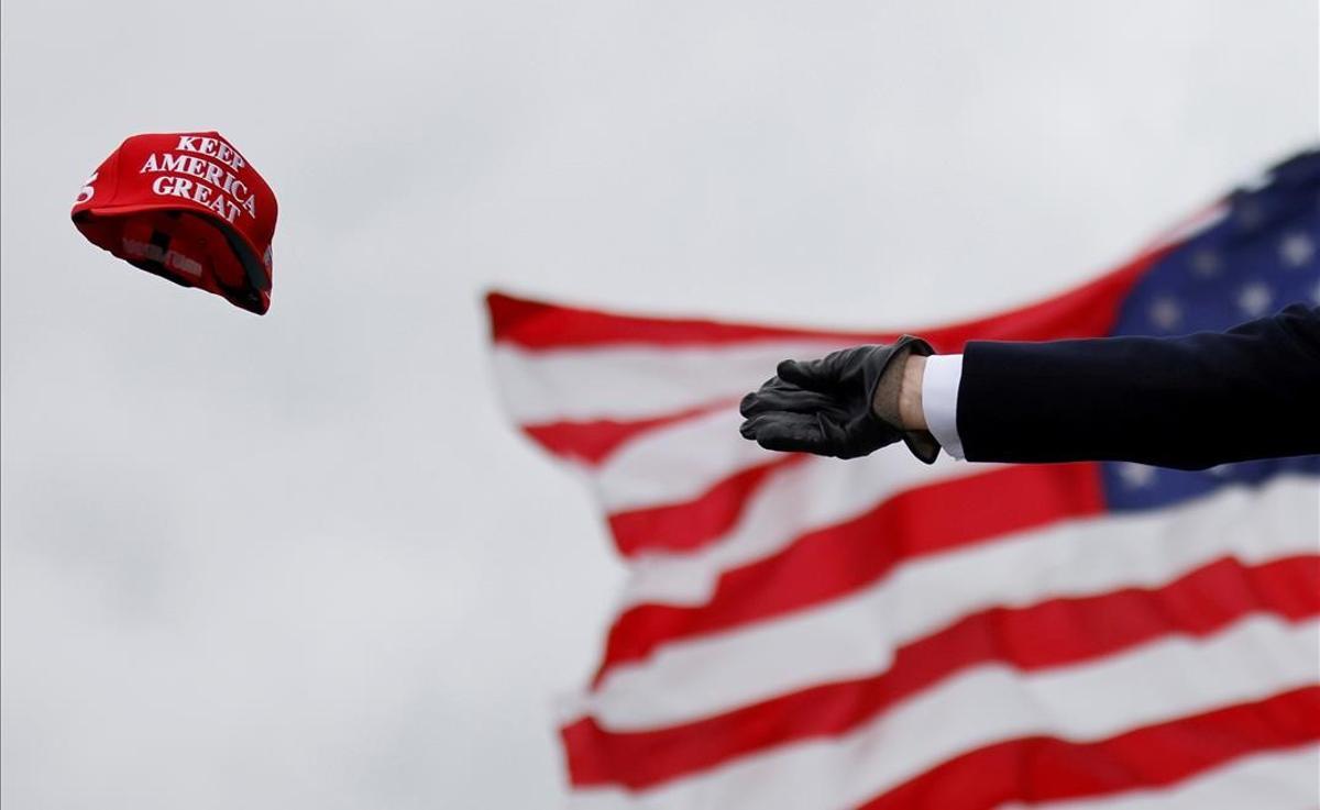 Donald Trump lanza gorras con el lema ’Keep America Great’ a su llegada a un acto de campaña en el aeropuerto internacional de Oakland County, en Waterford, Michigan, el 30 de octubre del 2020.