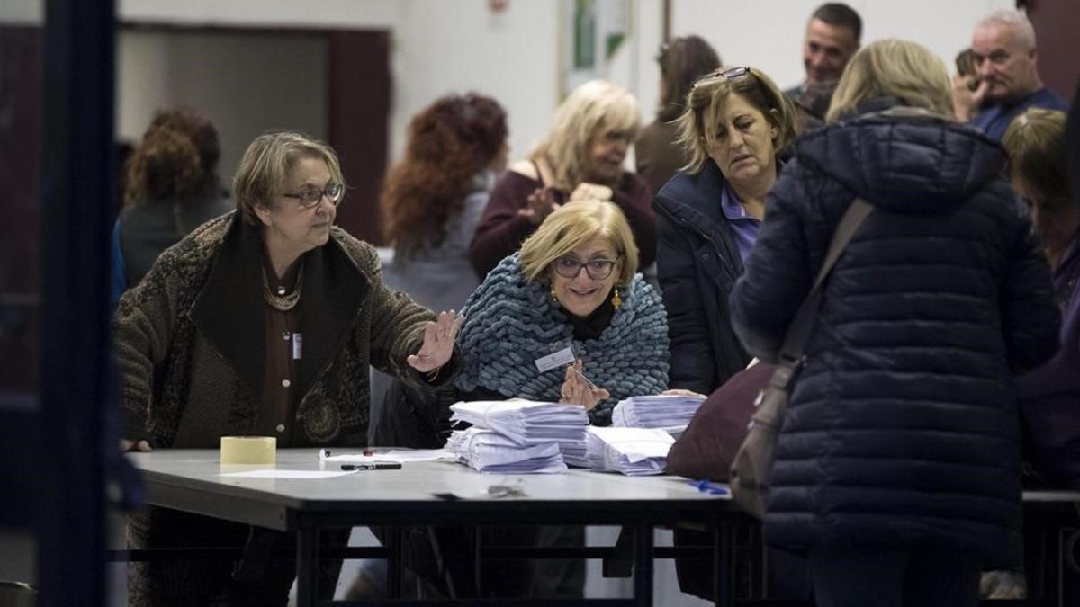 Miembros de una mesa electoral abren los sacos con las papeletas del referéndum