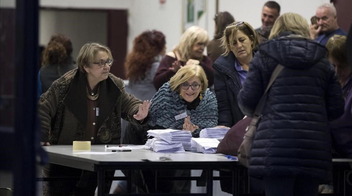 Miembros de una mesa electoral abren los sacos con las papeletas del referéndum.