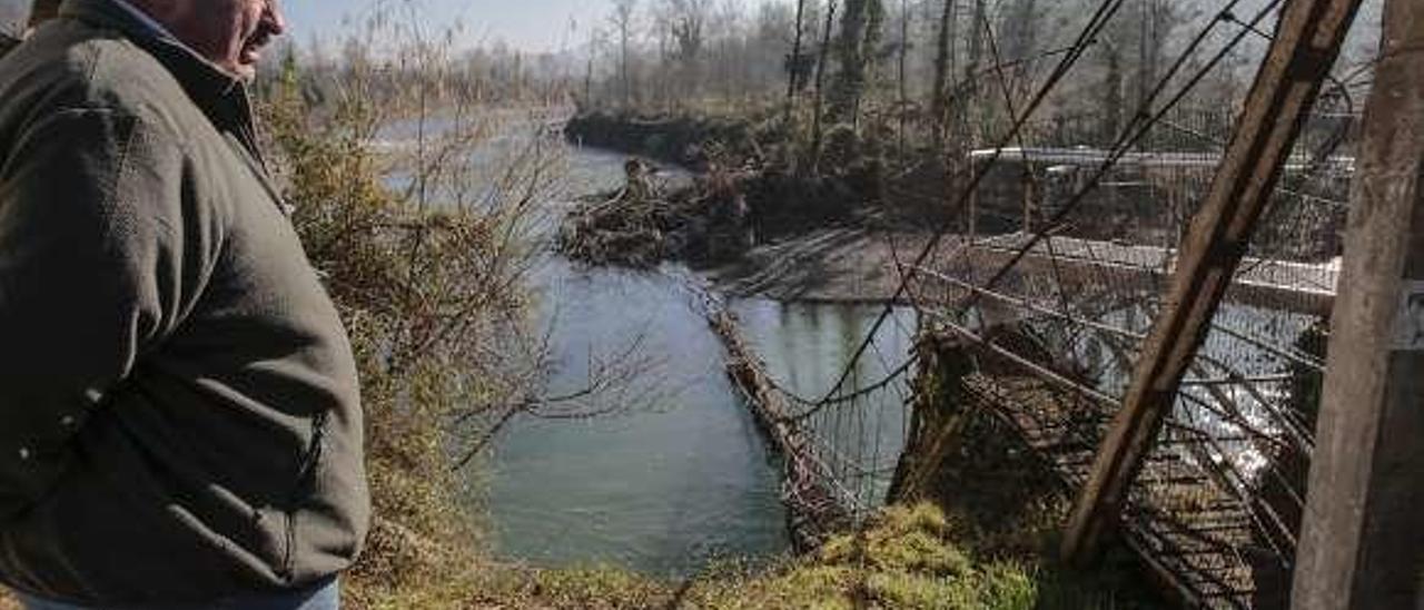 Arriba, Luis Díaz, junto a los restos del puente colgante que se cayó al río durante el último temporal. Abajo, suciedad acumulada y un pozo de captación. En el círculo, Sebastián Losada indica los niveles alcanzados por el agua durante algunas inundaciones.