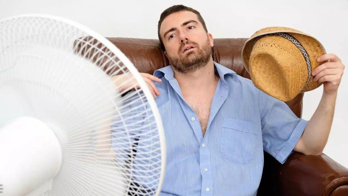 Un hombre delante de un ventilador.