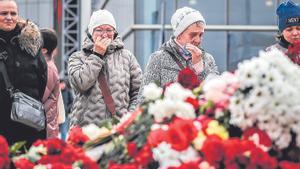 Mujeres ante flores colocadas en memoria de los fallecidos en el atentado de Moscú.