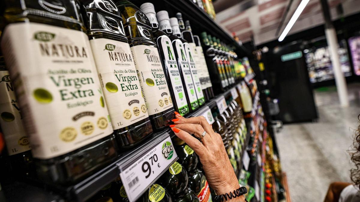 Una mujer elige entre varias botellas de aceite en un supermercado de Barcelona