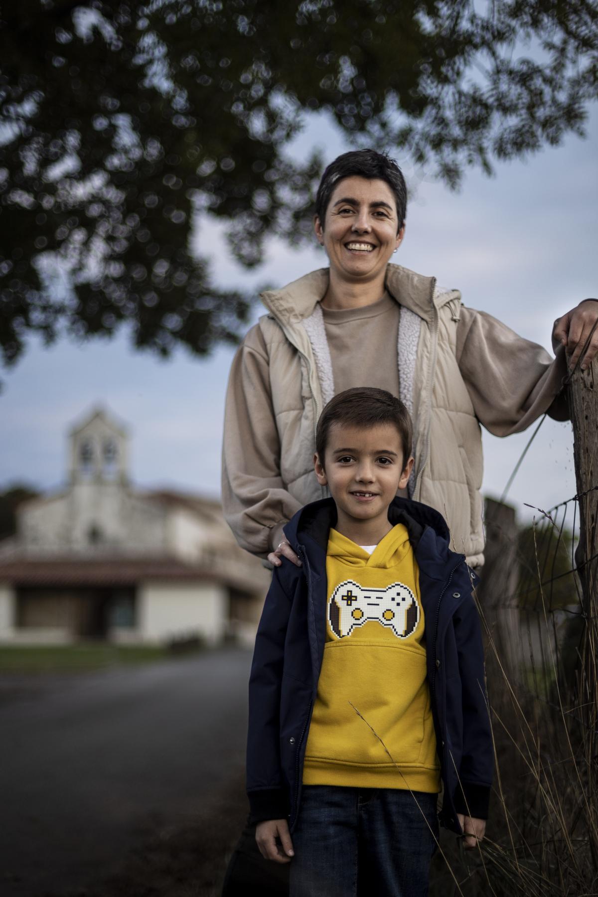 Tamara Samartino, con su hijo Xune, ante la iglesia de Santiago el Mayor  de Sariego.