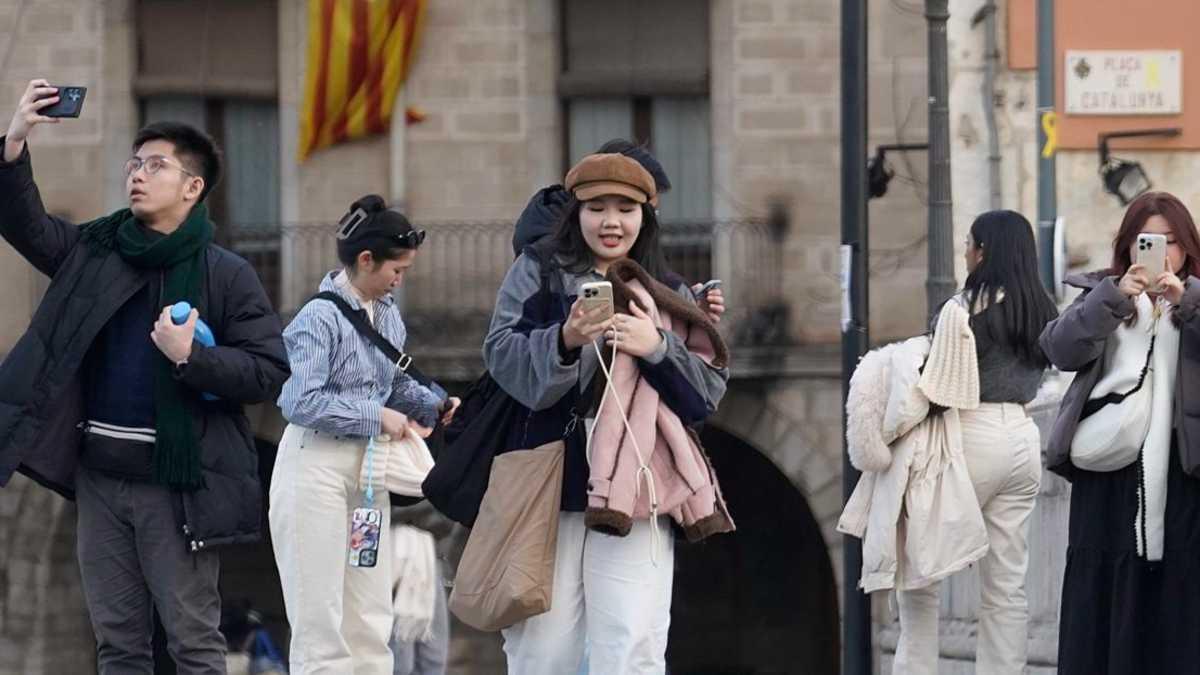 Un grup de turistes asiàtics al Pont de Pedra de Girona.