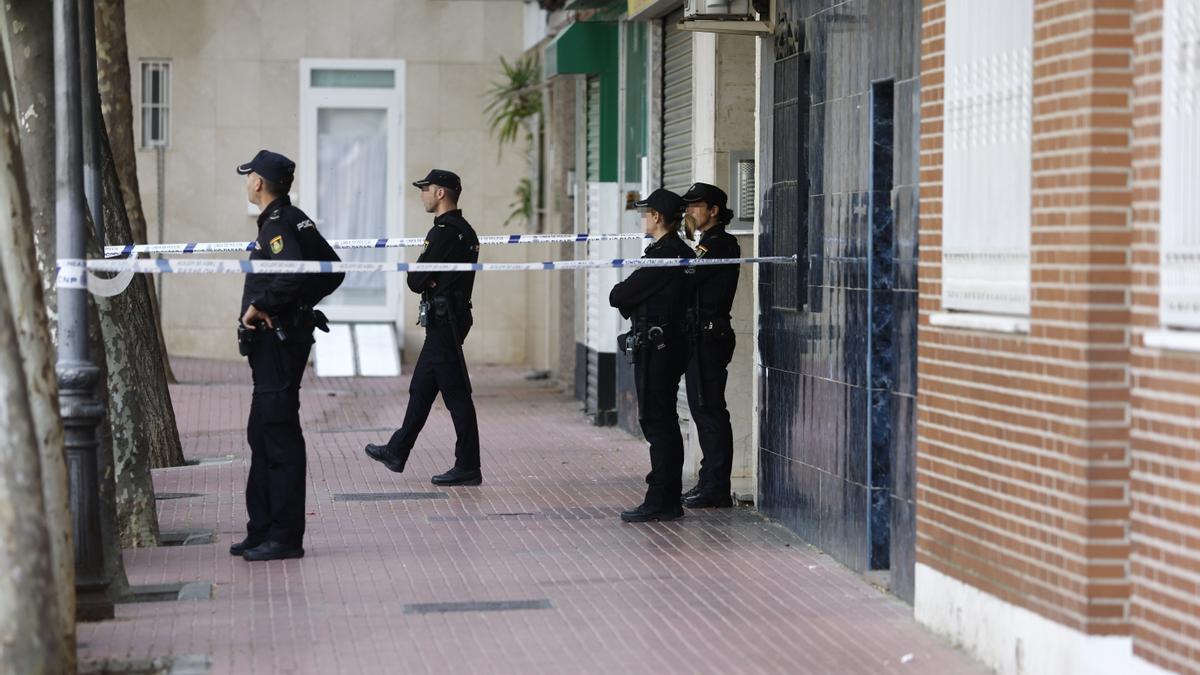 Agentes de la Policía junto al portal de la vivienda en la que fue acuchillada la víctima.