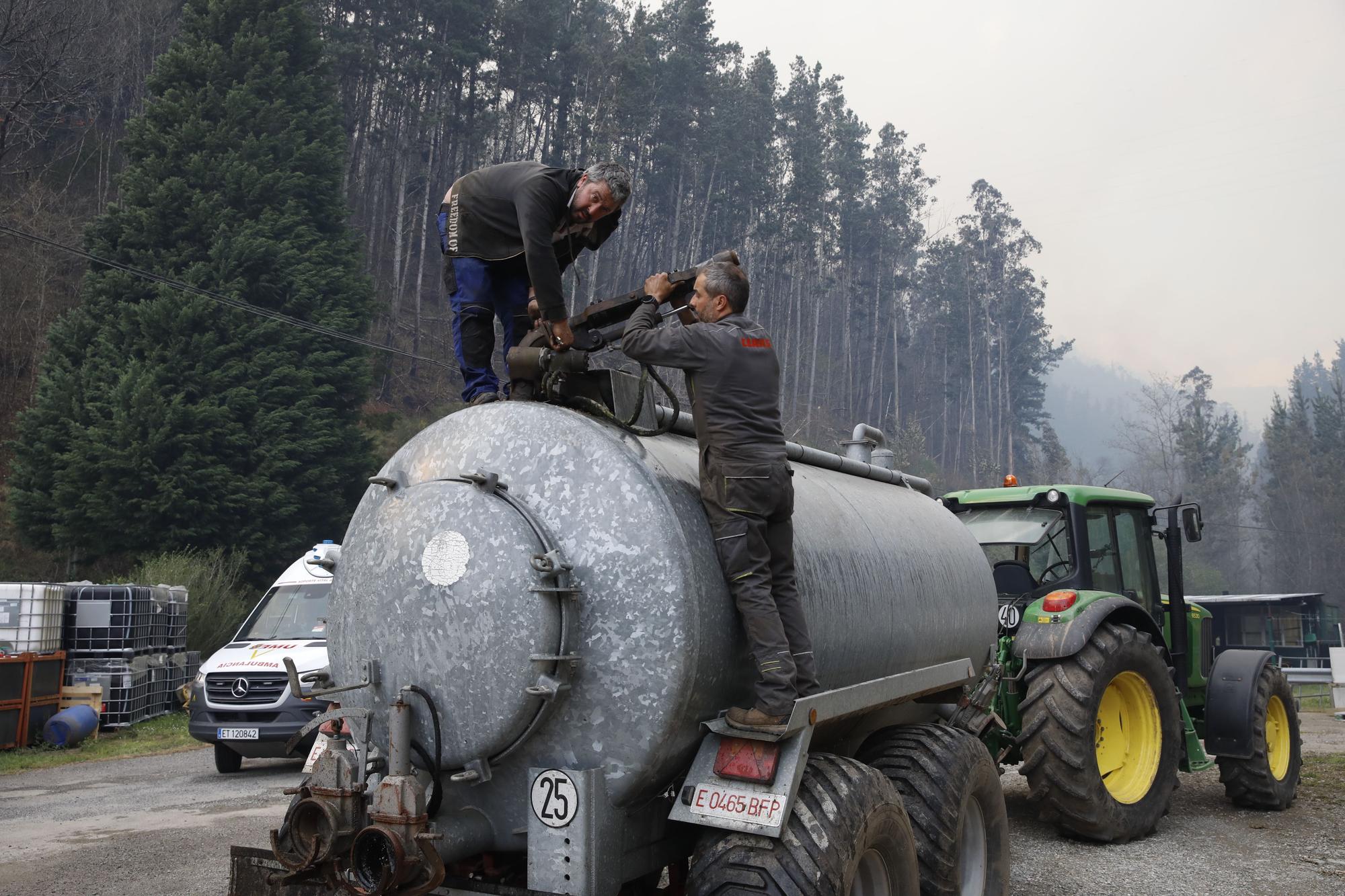 Agricultores ayudando en la extinción de los focos de fuego y enfriando las inmediaciones de la gasolinera de Navelgas