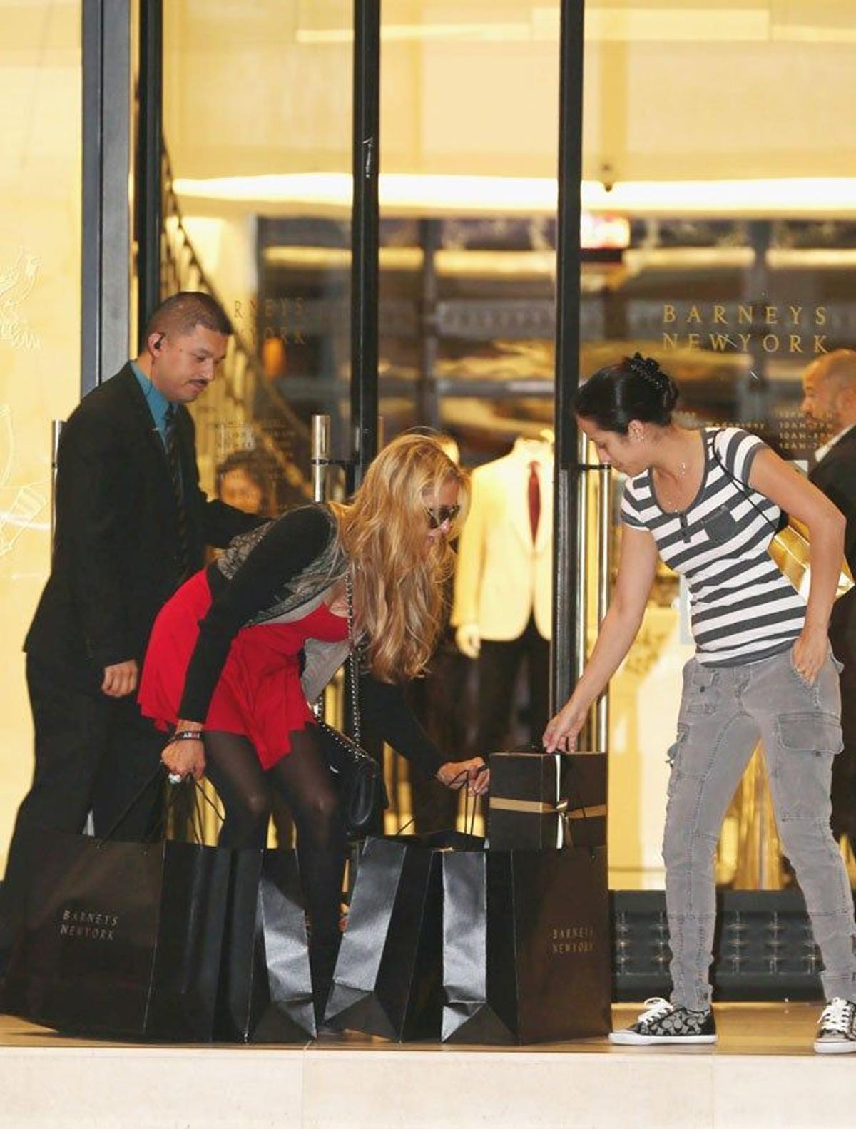 Una chica le echa una mano a Paris Hilton con sus bolsas