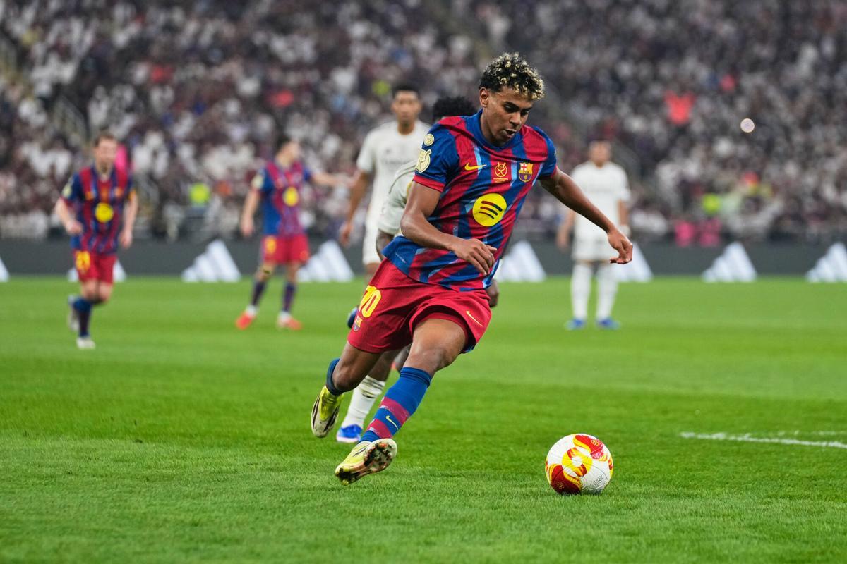 Barcelona's Lamine Yamal runs with the ball during the Spanish Super Cup final soccer match against Real Madrid at King Abdullah Sports City Stadium in Jeddah, Saudi Arabia, Sunday, Jan. 11, 2026. (AP Photo/Altaf Qadri)