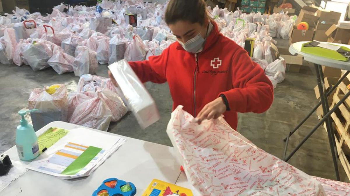 Una voluntària de Creu Roja, preparant regals.  | DIARI DE GIRONA