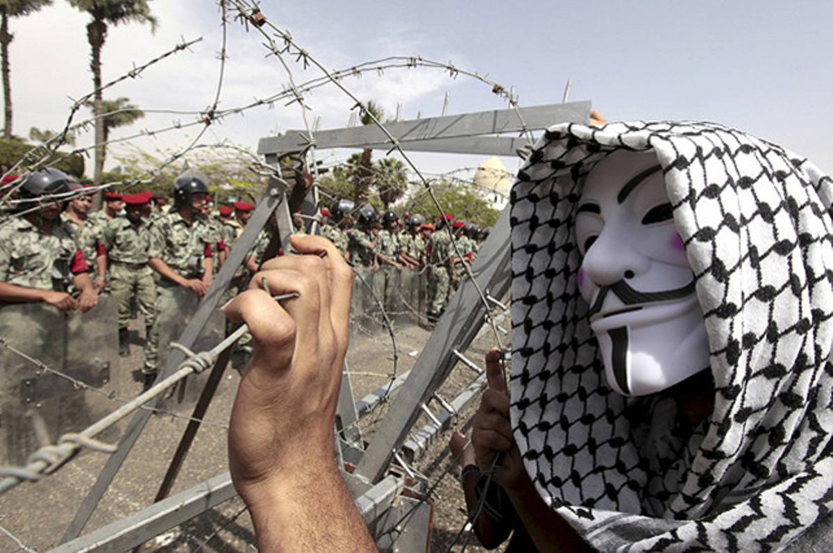 Un manifestant, davant la policia militar en una delegació del Ministeri de Defensa del Caire, on els activistes estan demanant la formació d’un govern de transició.