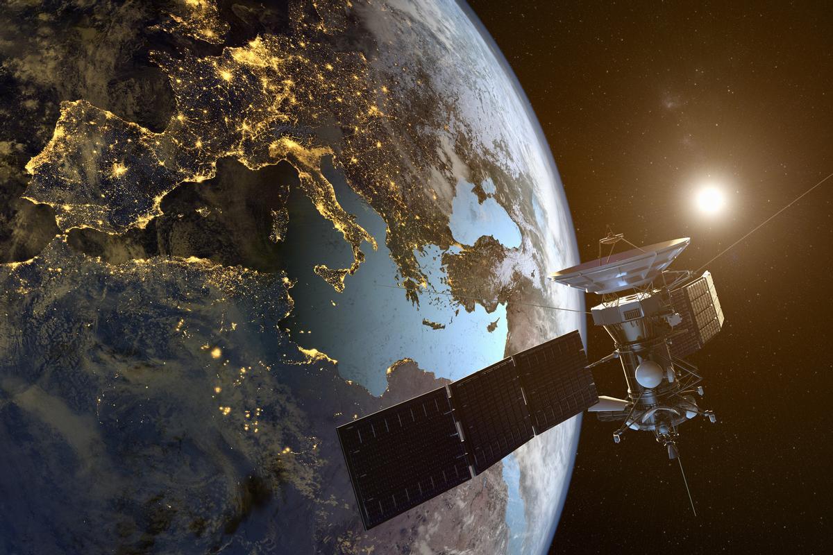 Un satélite orbitando la tierra con las ciudades iluminadas en la noche