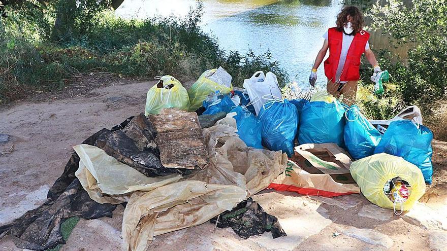 Una participante en la recogida observa la multitud de bolsas de basura.