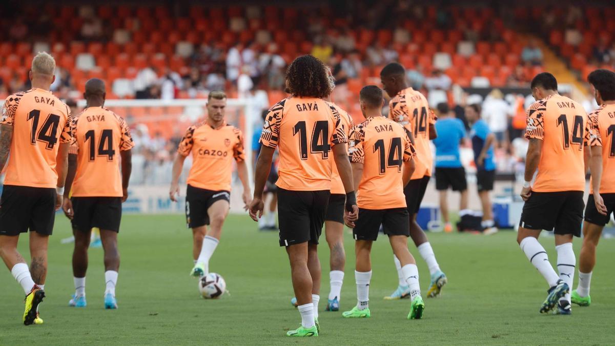 Los jugadores del Valencia CF calientan con el nombre y el dorsal de Gayà en la espalda