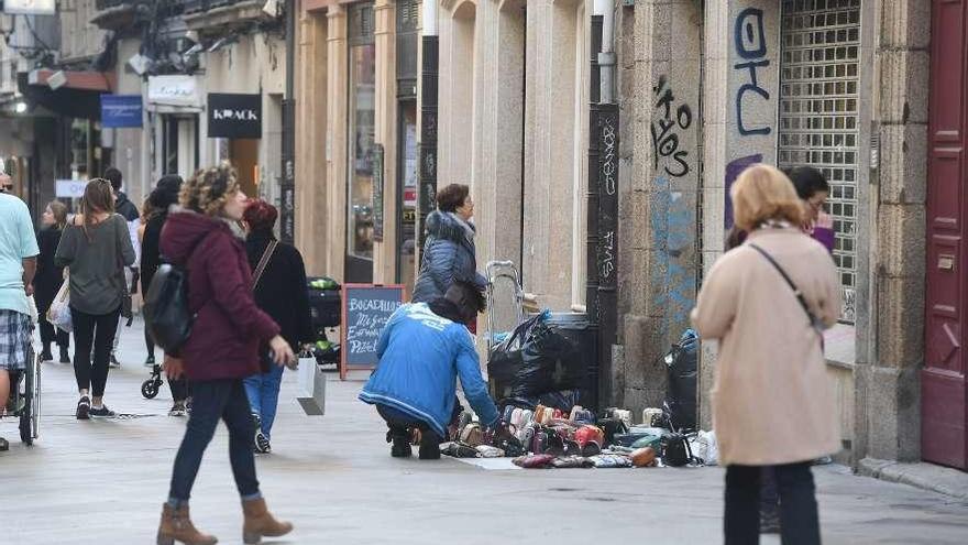 Un &#039;mantero&#039; coloca mercancía en la calle Real.