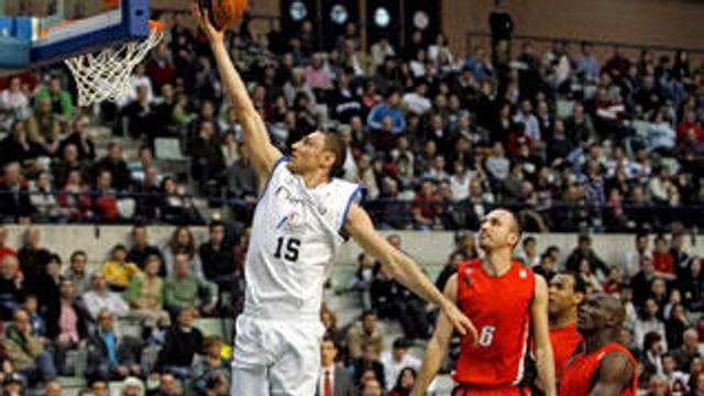 El ala-pívot lituano del Meridiano Alicante, Mindaugas, se dispone a encestar ante la impotencia del escolta del C.B Murcia, Pedro Robles (3d) y sus compañeros Amara Sy (d) y Paulao Prestes (2d), durante el partido que ambos equipos disputaron en el Palacio de los Deportes de Murcia, correspondiente a la vigesimosexta jornada de la liga ACB.