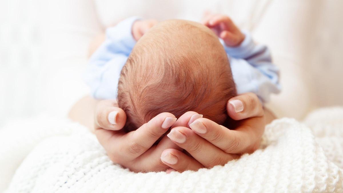 Una mujer sostiene a un bebé recién nacido.