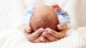 Una mujer sostiene a un bebé recién nacido.