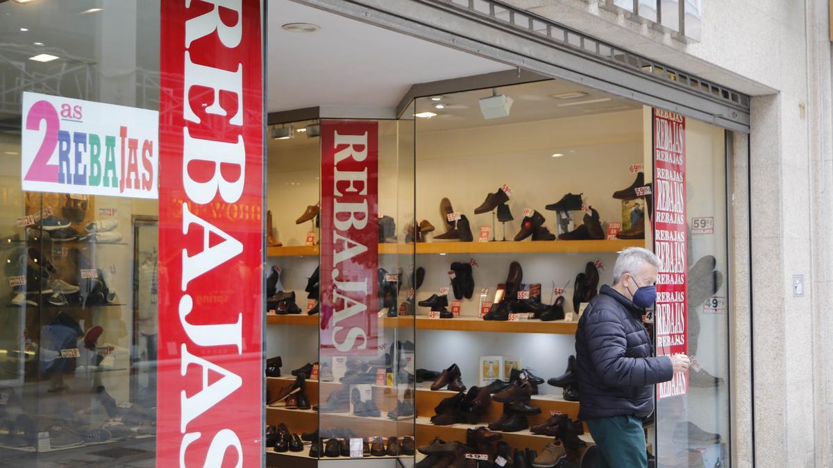 Un hombre sale de un comercio en rebajas de Vigo