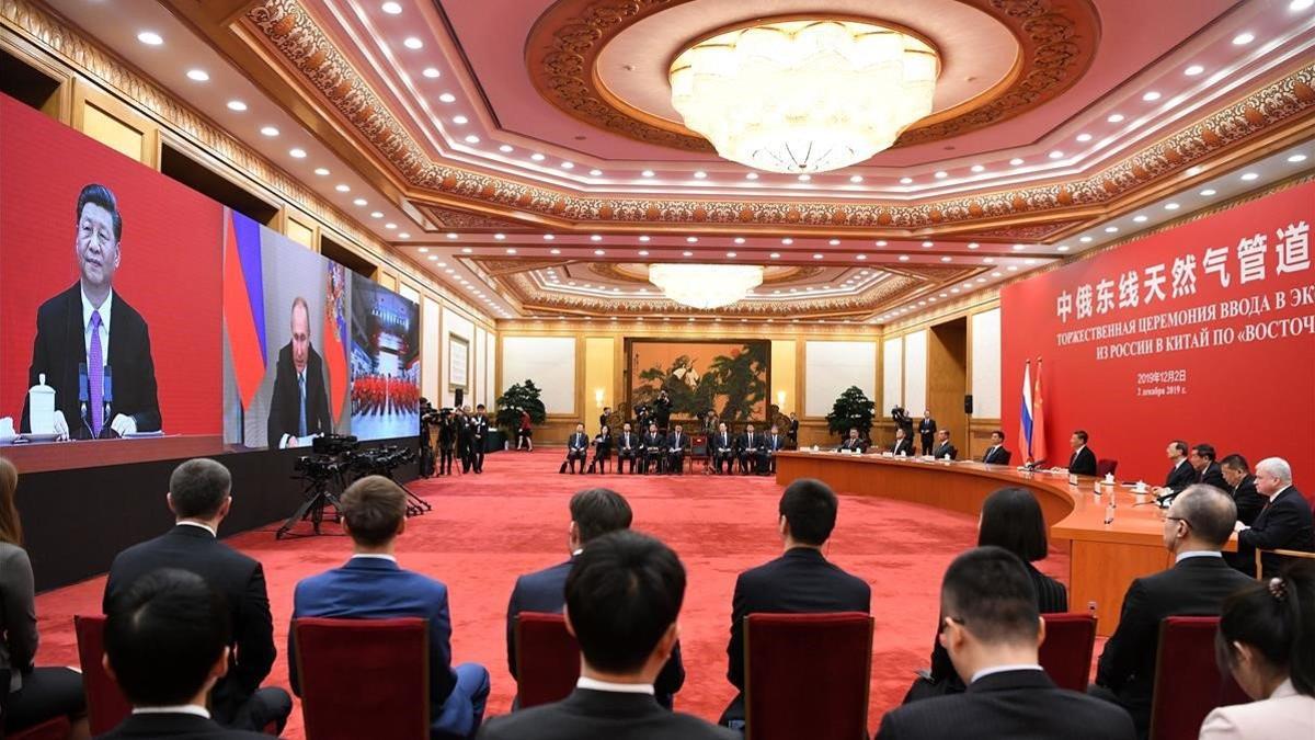 El presidente de Rusia, Vladimir Putin (pantalla del centro) dialoga con su homólogo chino, Xi Jinping, por videoconferencia en la ceremonia de inauguración de un nuevo gasoducto ruso a China.