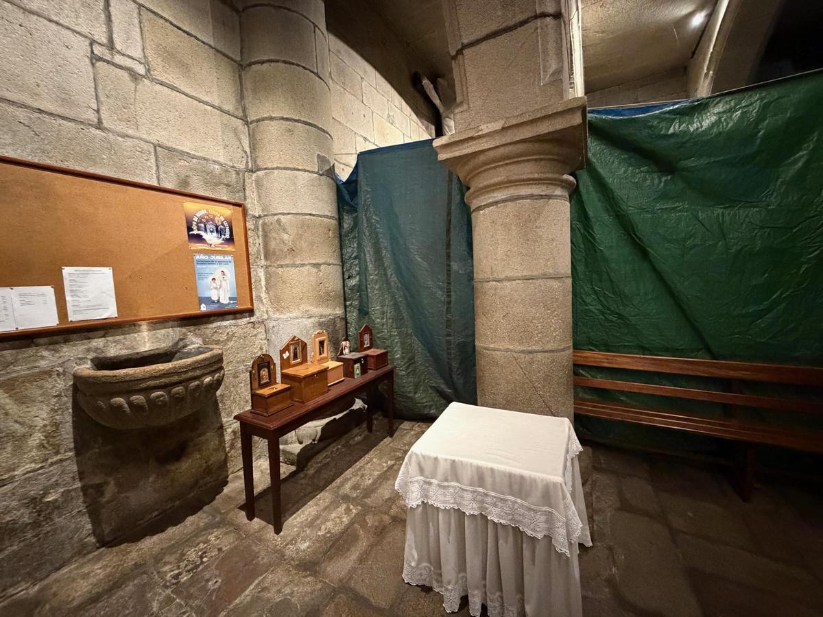 Pila bautismal en obras y oculta por una lona, tras la que fue detectada una de las mujeres.