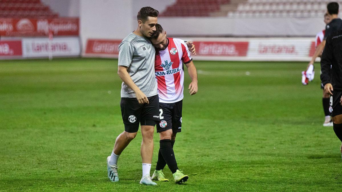 Carlos Parra recibe consuelo de un compañero tras acabar el partido de ayer.