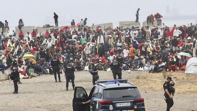 La policia vigila els migrants a El Trampolín, a Ceuta, ahir. | REDUAN / EFE
