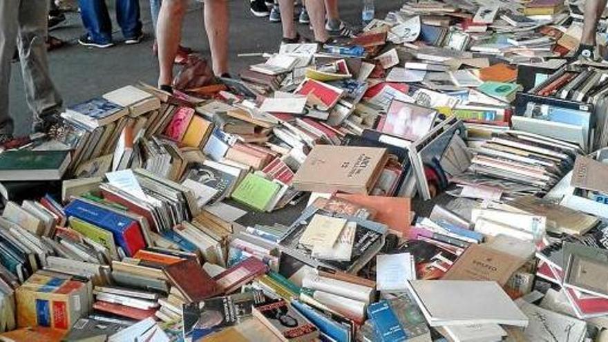 Llibres de la biblioteca Ràfols-Casamada i Maria Girona tirats a terra en una parada dels Encants, divendres