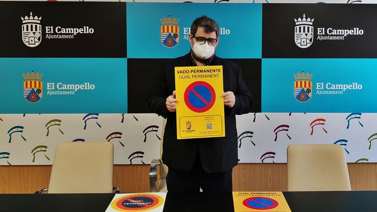 El concejal Javier Martín sostiene la nueva placa con QR para comprobar si está en vigor, junto a otras dos placas antiguas.