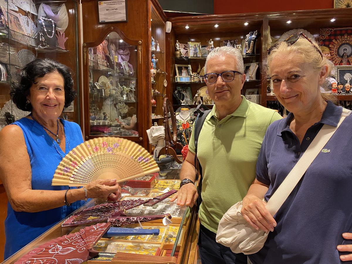 Isabel Bellostas en su tienda con unos turistas italianos.