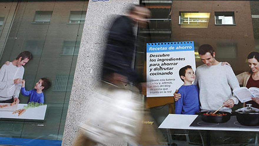 Un hombre pasa junto a una oficina bancaria.