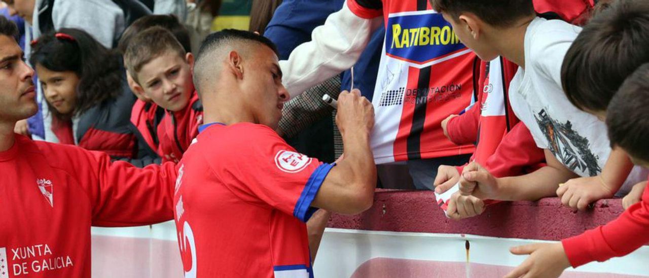 Duque firma una camiseta en A Lomba. | Noé Parga