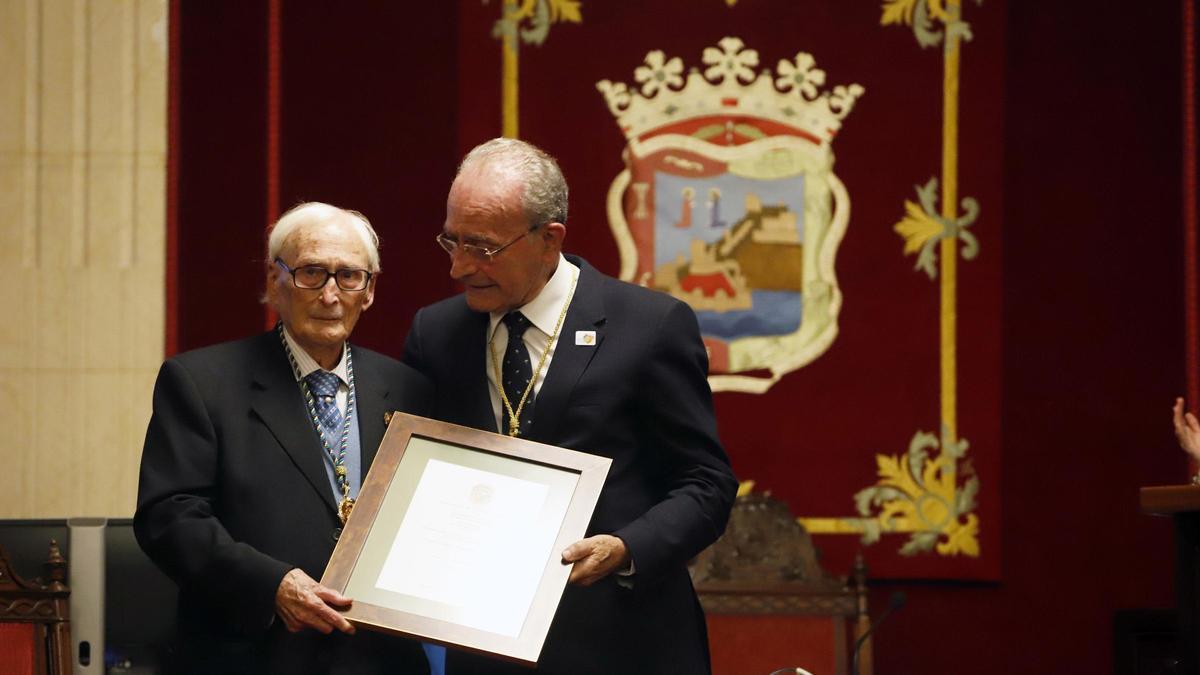 El alcalde de Málaga, Francisco de la Torre (d), hace entrega de la Medalla de la Ciudad y Título de Hijo Predilecto al cinéfilo y periodista Guillermo Jiménez Smerdou el 14 de diciembre de 2022.